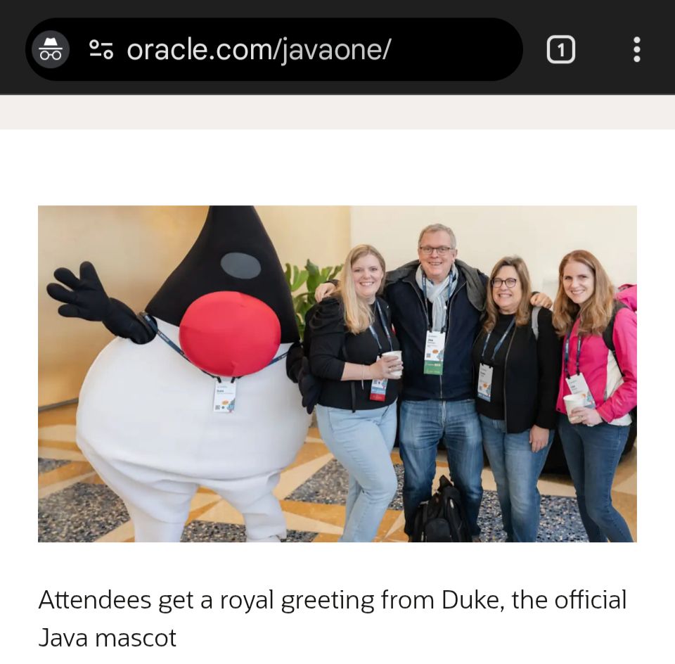 Image on Oracle's website of various technical conventiongoers greeted by someone in a Java Duke costume. Duke is some kind of white-and-black triangle with hands, feet, and a single red eye. Kind of a baffling mascot