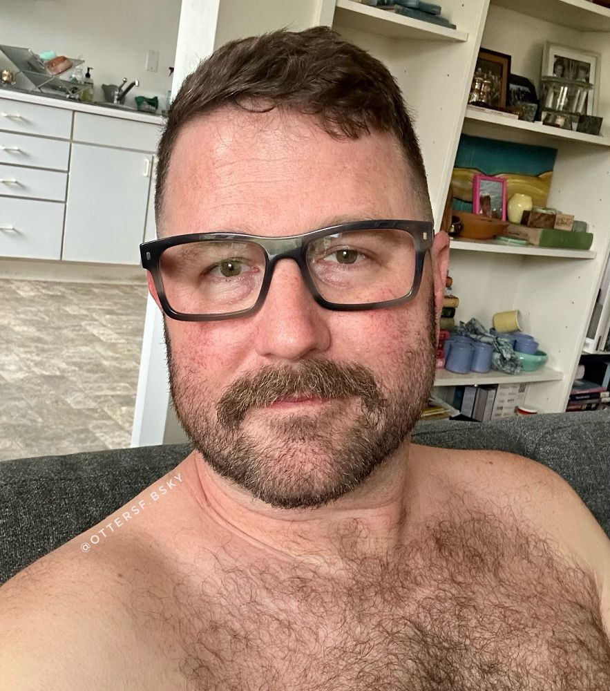 Shirtless couch selfie wearing glasses