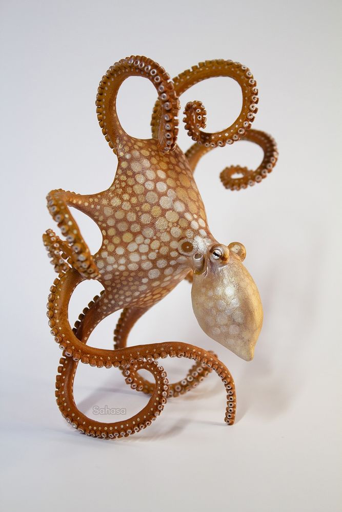 A flowy octopus sculpture depicting the species "Octopus cyanea", also known as the Day Octopus.

It's leaning back on three arms, the others arms are curled toward its body.

The octopus's arms are fully detailed with two neat rows of carefully sculpted suckers.

The paintwork is a warm ochre brown with creamy pearl spots, based on one of the many color expressions of this species.