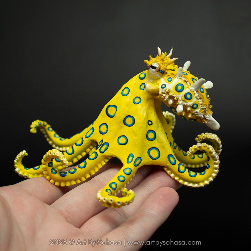 Photo of a feisty blue ringed octopus sculpture sitting on the artist's hand 