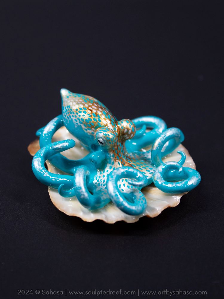 A small octopus sculpture sits in a shell 