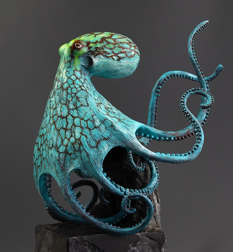 A vibrant Caribbean Reef Octopus sculpture, leaning on a black base. 