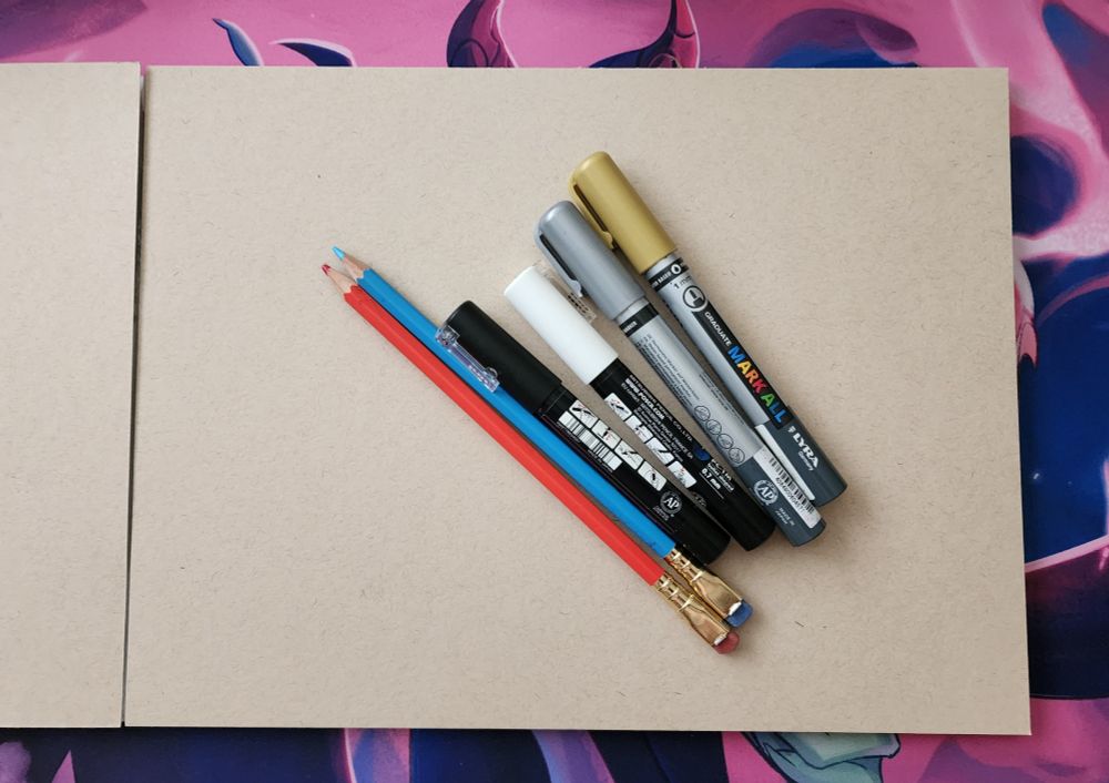 Photograph of some art supplies and some toned drawing paper