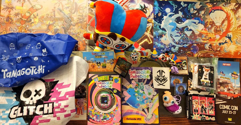 Photo of some Pokemon prints, totes bags, Amazing Digital Circus blind box figures, Pomni plush, Kinger keychain, Tamagotchi Paradise, a Popmart Peach Riot figure, a Disney Lorcana promo card, and various free promo postcards, posters, pins, etc.