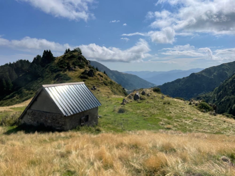 Une grange située sur un col, enherbé, avec vue sur le Couserans