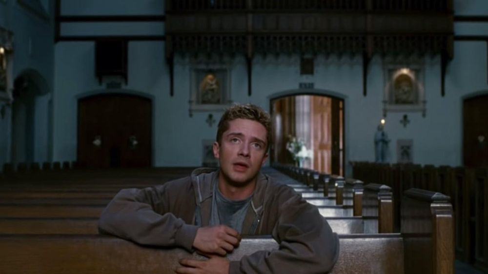 Blonde white man sitting in a church praying. From the Film Spider-man 3 where the character, Eddie Brock, prays for the death of his enemy. 