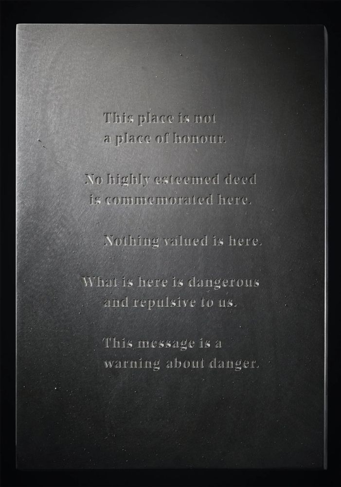 Plaque that reads:
"This is not a place of honour.

No highly esteemed deed is commemorated here.

Nothing valued is here

What is here is dangerous and repulsive to us

This message is a warning about danger."