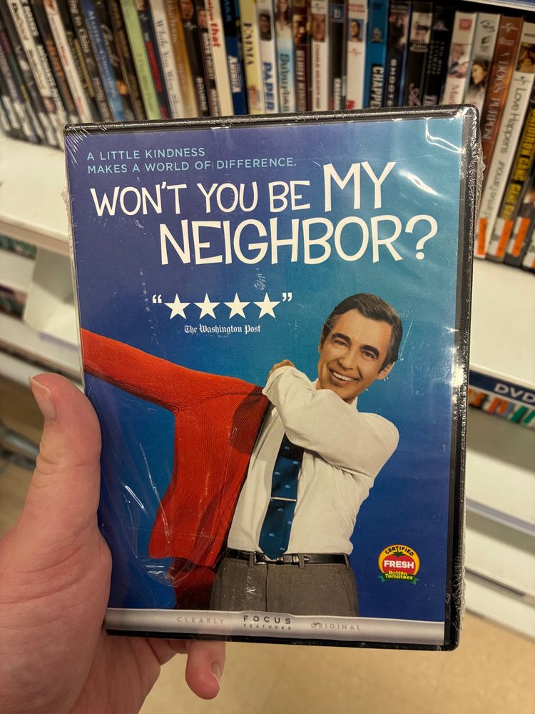 My hand holding a DVD copy of Won’t You Be My Neighbor? (2018).