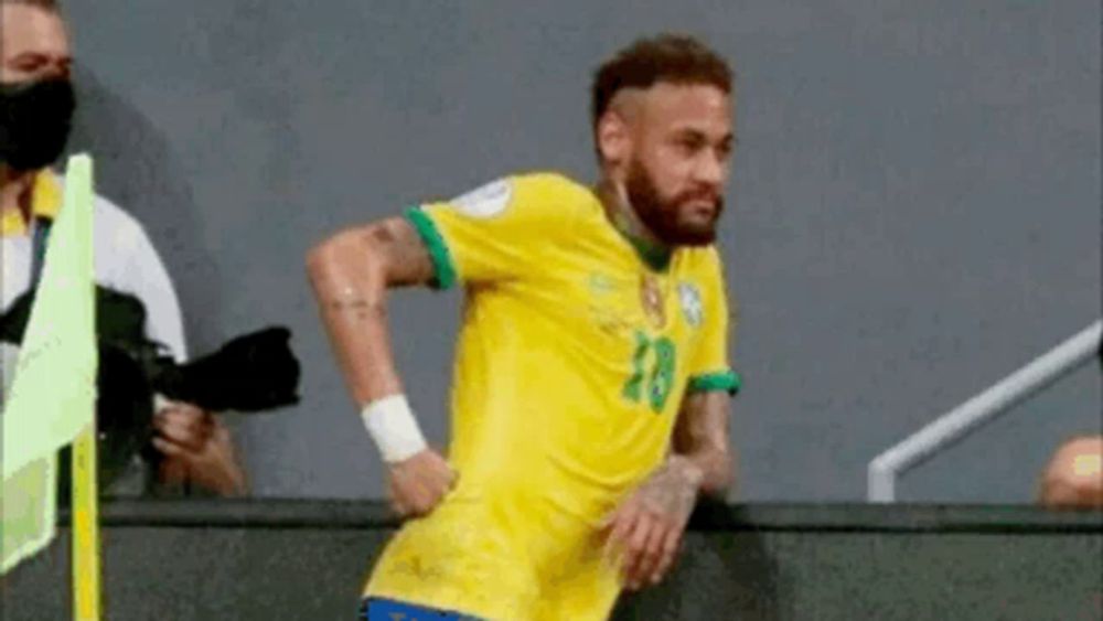 a soccer player in a yellow and green jersey is standing on a soccer field .