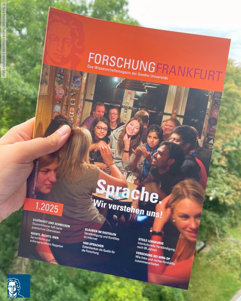 Hier wird das Wissenschaftsmagazin vor einem Naturhintergrund in der Hand gehalten. 