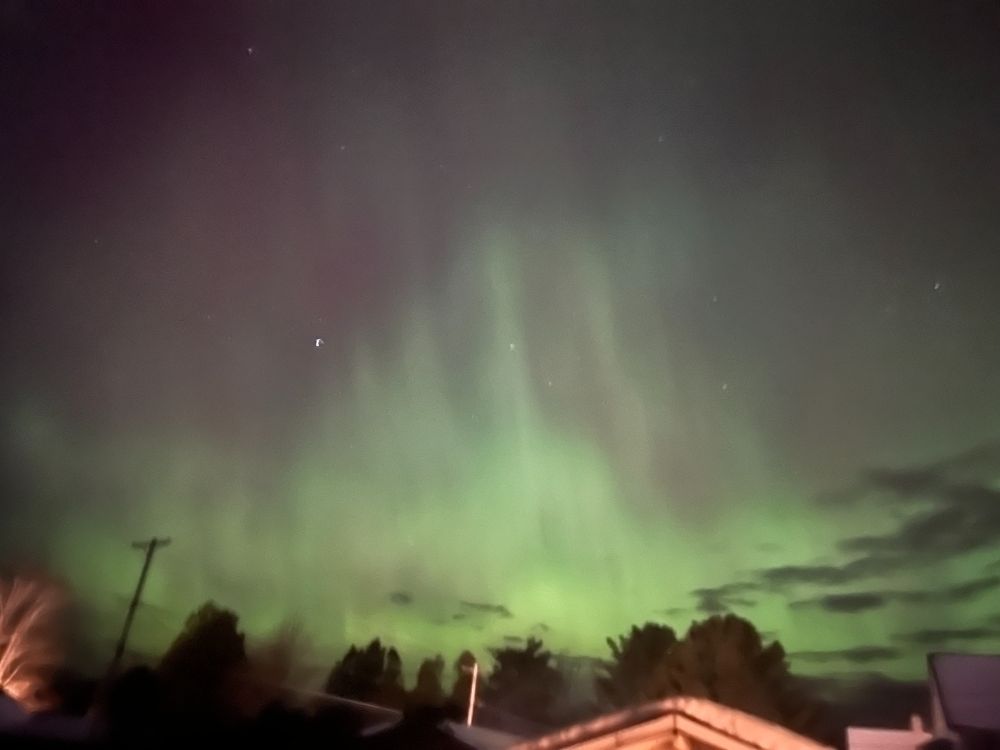 Streamers of aurora borealis tower into the night sky