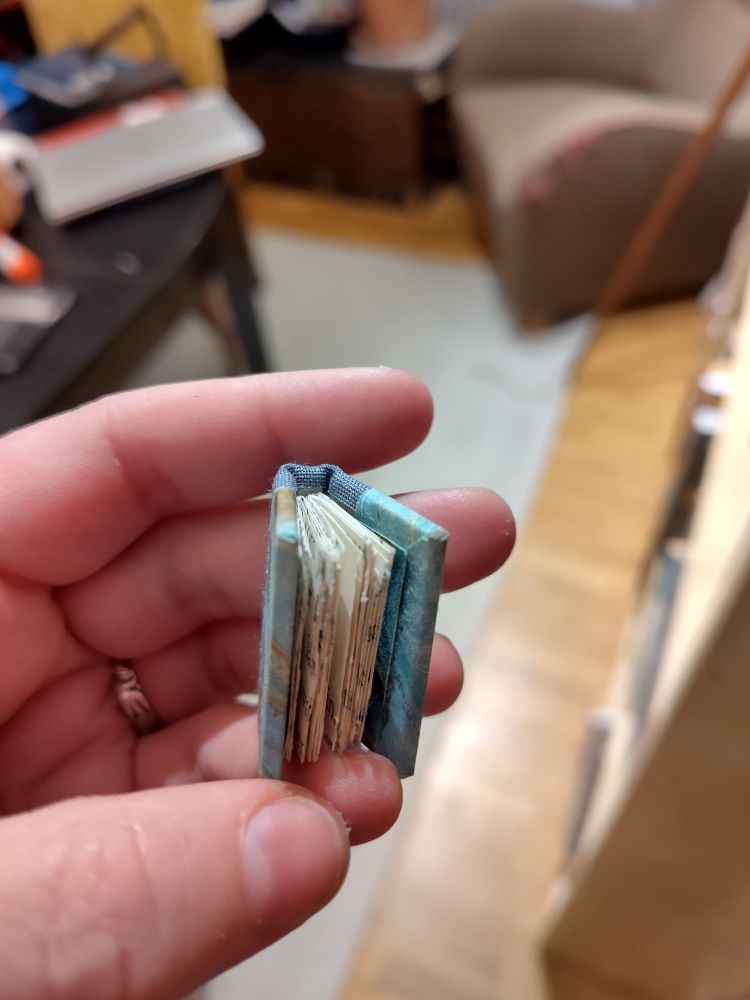 A different view of the tiny book, showing the pages inside.