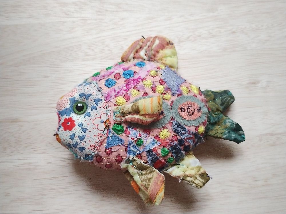 魚のぬいぐるみ　丸っこいような菱形のようなフォルム　体表には刺繍が施されている