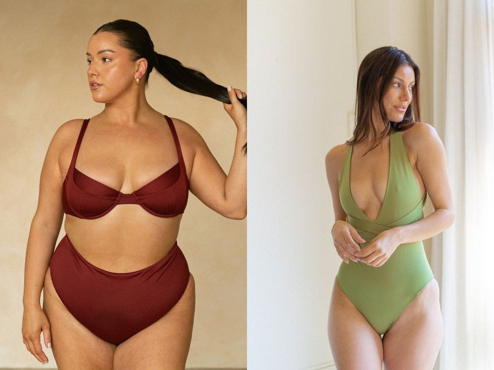 Two women. The woman on the left is wearing a maroon bikini with structured cups. The woman on the right is wearing a pale green, minimalist one-piece swimsuit.