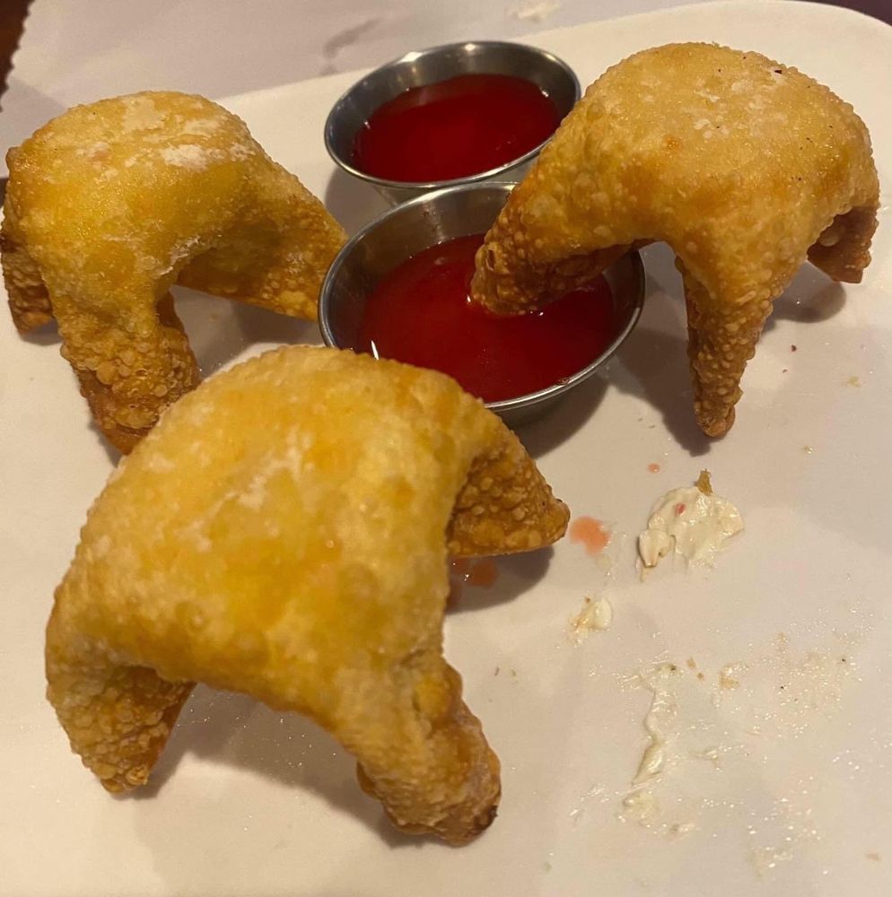 Crab rangoons set upside down gathered by some sauce