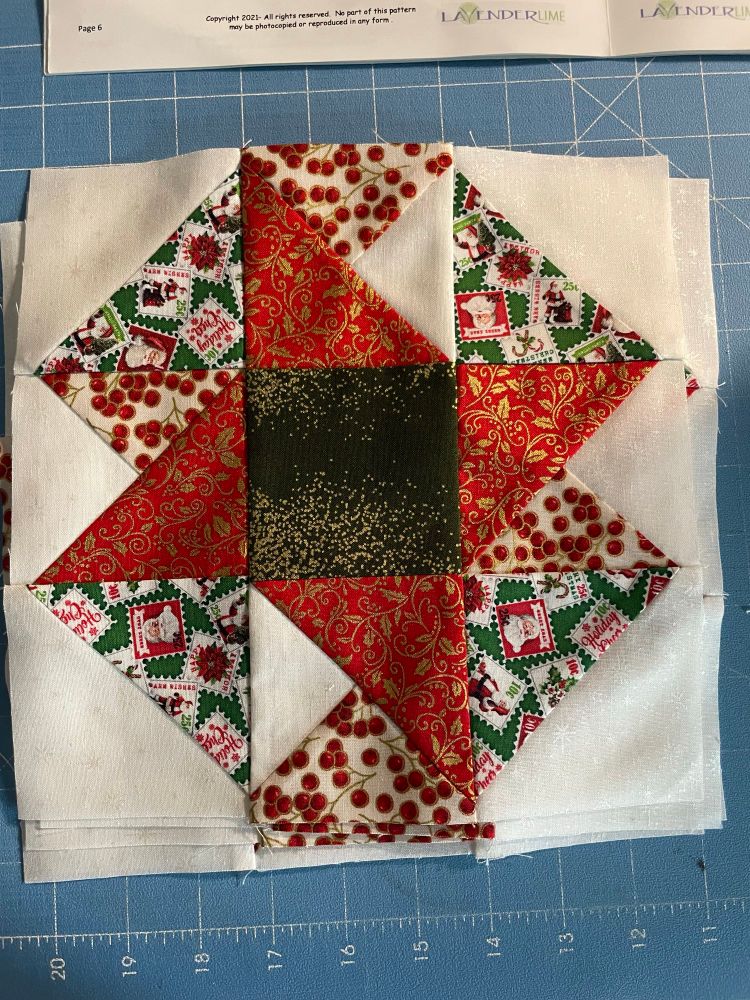 A pinwheel block of a quilt in Christmas themed fabrics