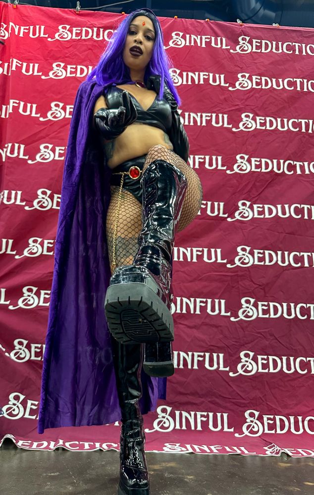 Goddess Raven Noxx showing her boot to her wiling simp for worship while cosplaying as Raven from DC Comics 
