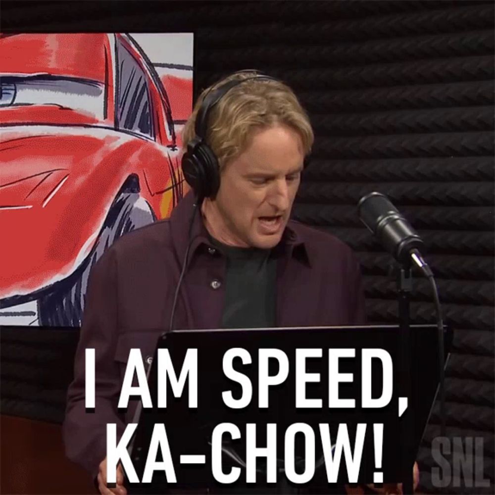 a man wearing headphones says i am speed ka-chow in front of a microphone