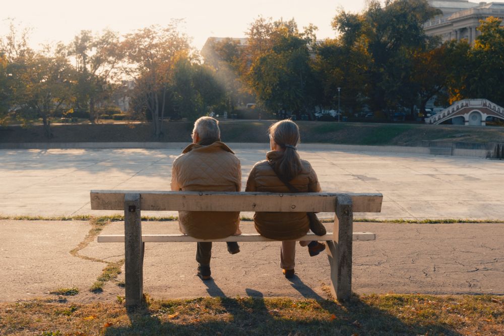 A couple sat on a bench in golden hour