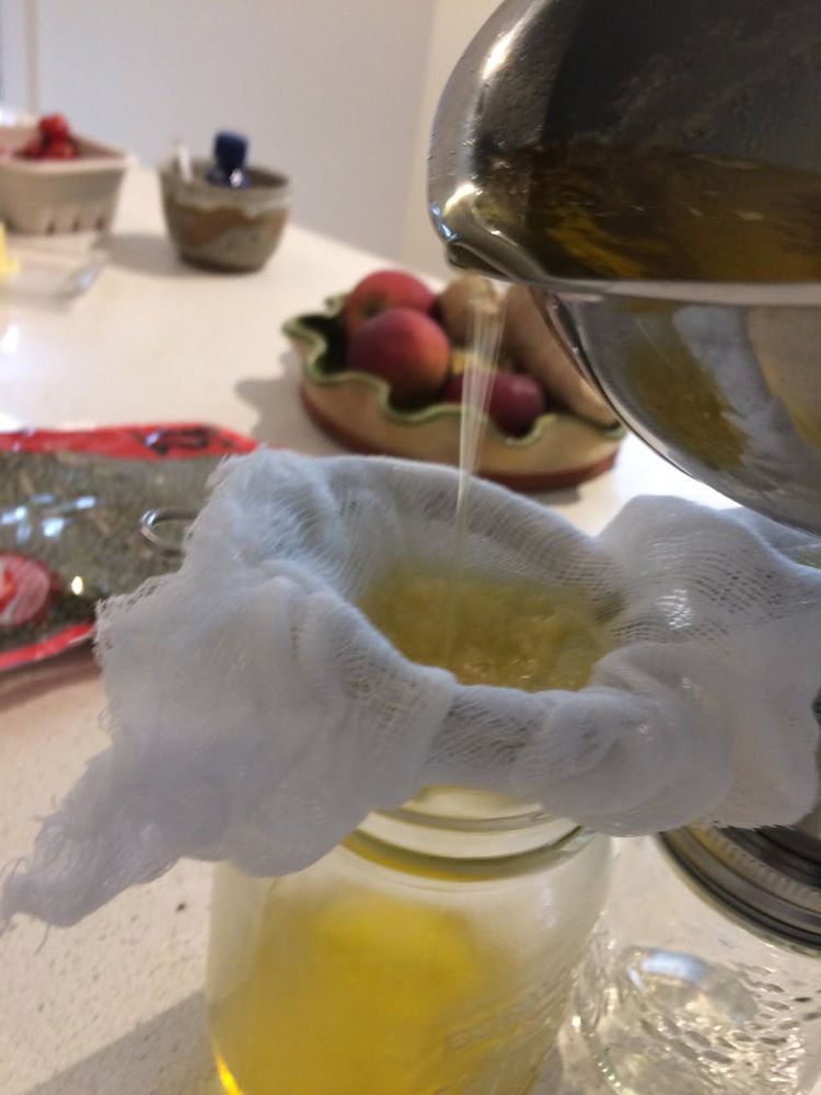 pouring hot clarified butter through a strainer lined with cheesecloth