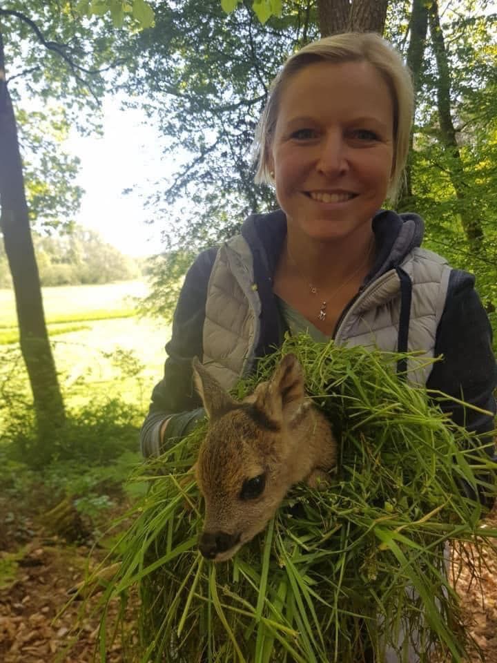 Eine Frau mit einem Rehkitz im Arm