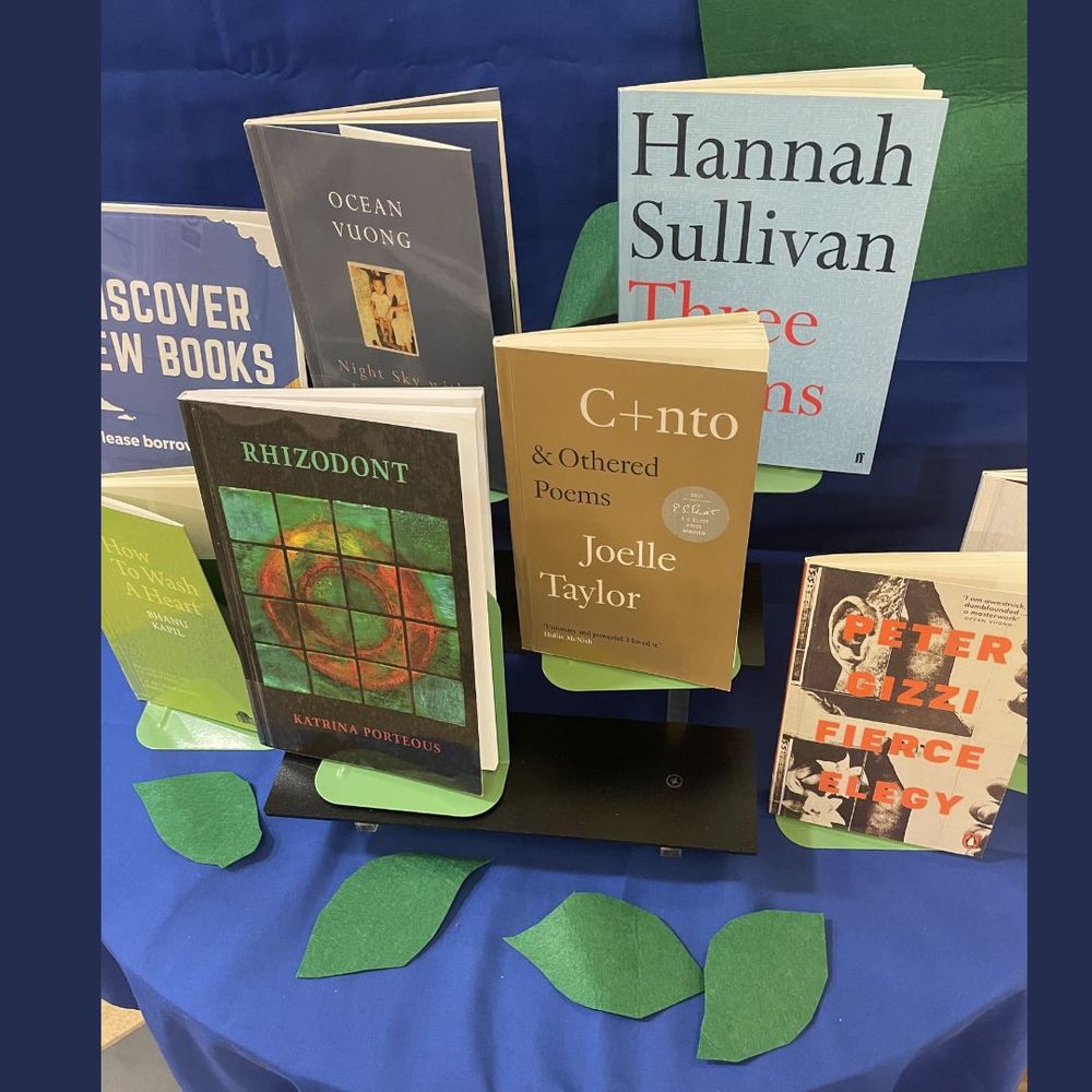 Display of books shortlisted for the TS Elliot poetry prize 2024 on a blue cloth with green leaves