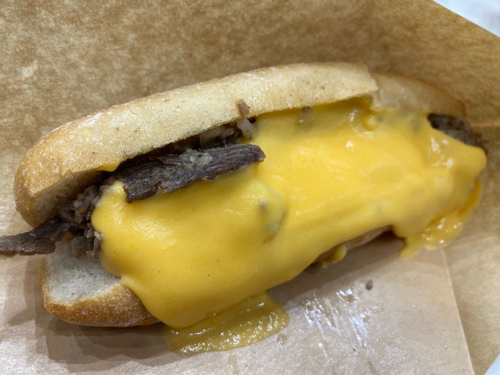 チーズステーキサンド。焼いたソフトフランスパンに薄切りビーフとたっぷりのとろとろチーズがのってる。うまーい。