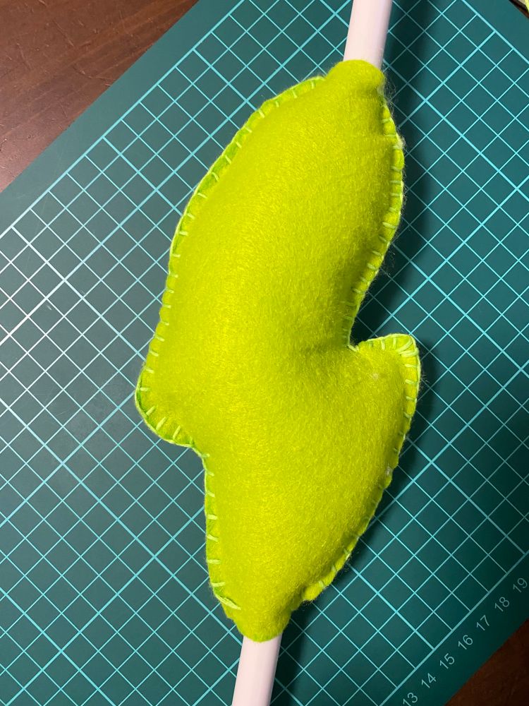 緑のフェルトを突っ張り棒に縫い付けてワタを入れた状態。何故か佐渡島みたいな形状になっている。