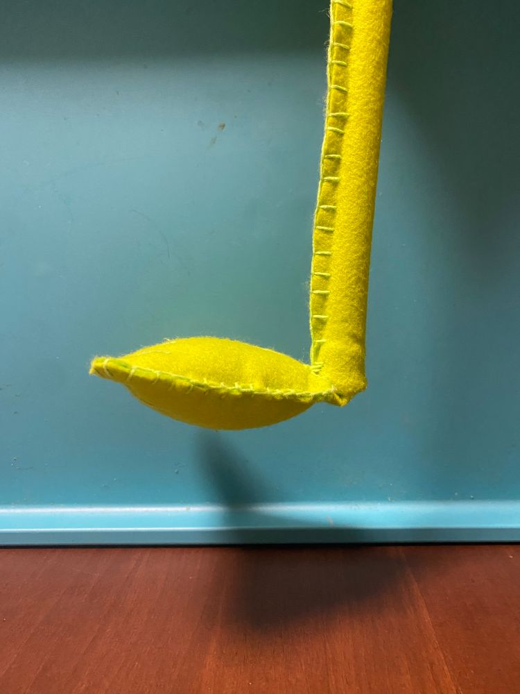 黄緑色のフェルトで突っ張り棒をくるみ、先端にワタを入れたパーツが縫い付けられている。角度がほぼ90度くらいになっている。