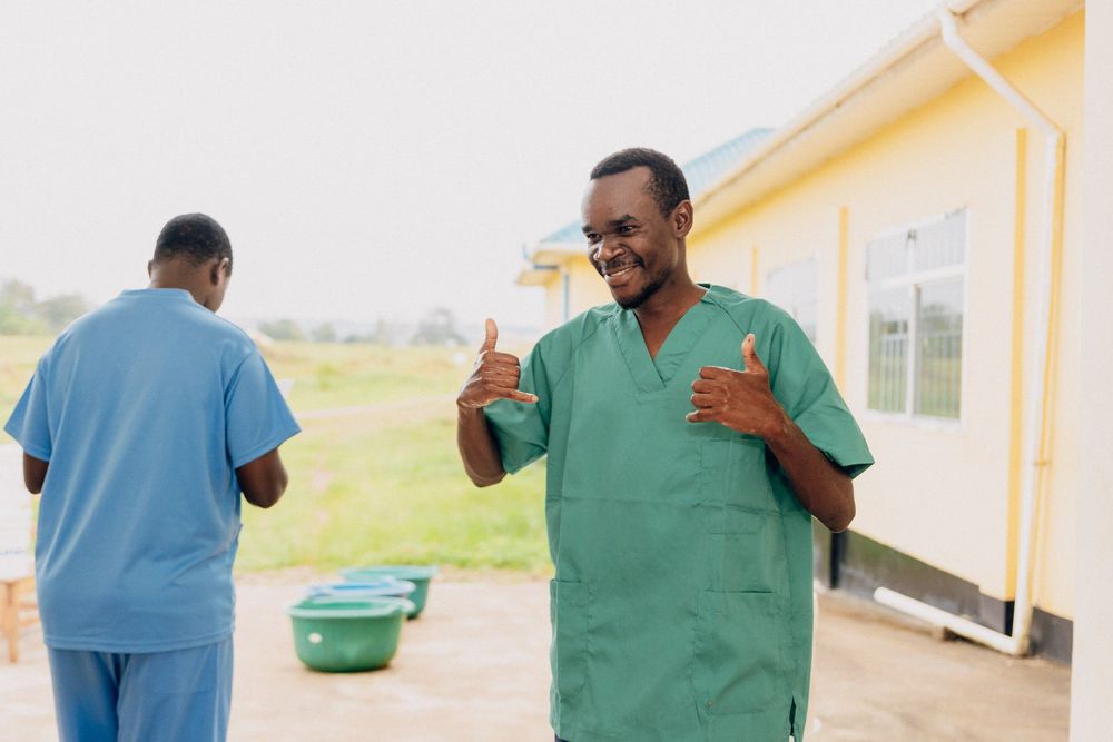 A happy healthcare worker is showing a thumbs up sign.