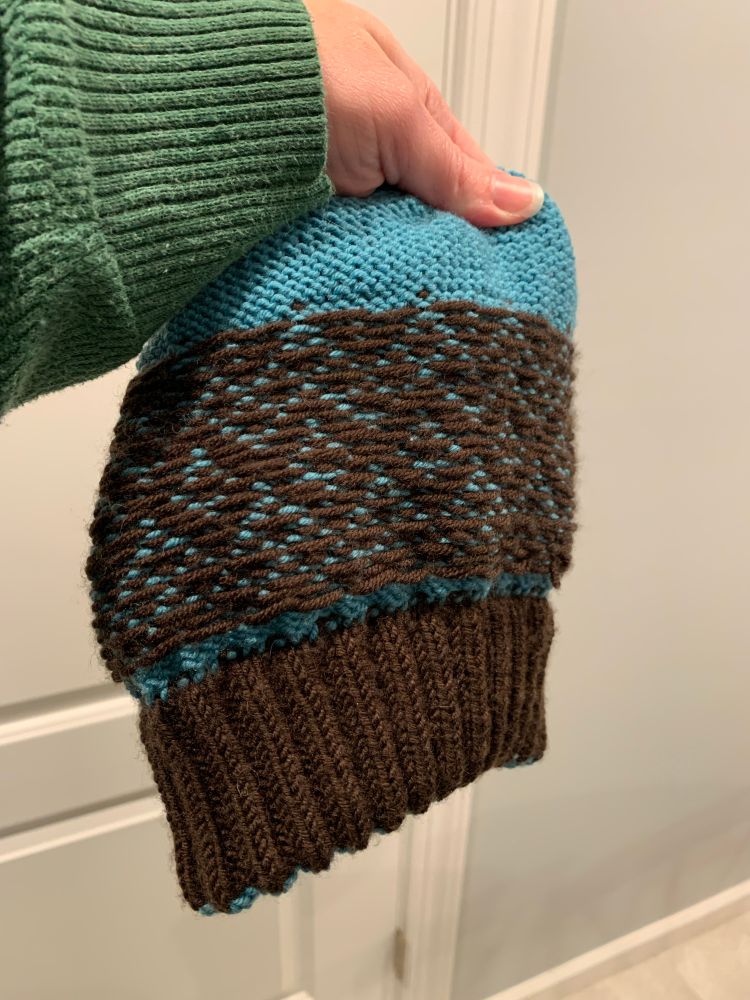 The same hat turned inside out to show the brown contrast color making up the inside ribbing of the brim and fairly neat floats behind the colorwork