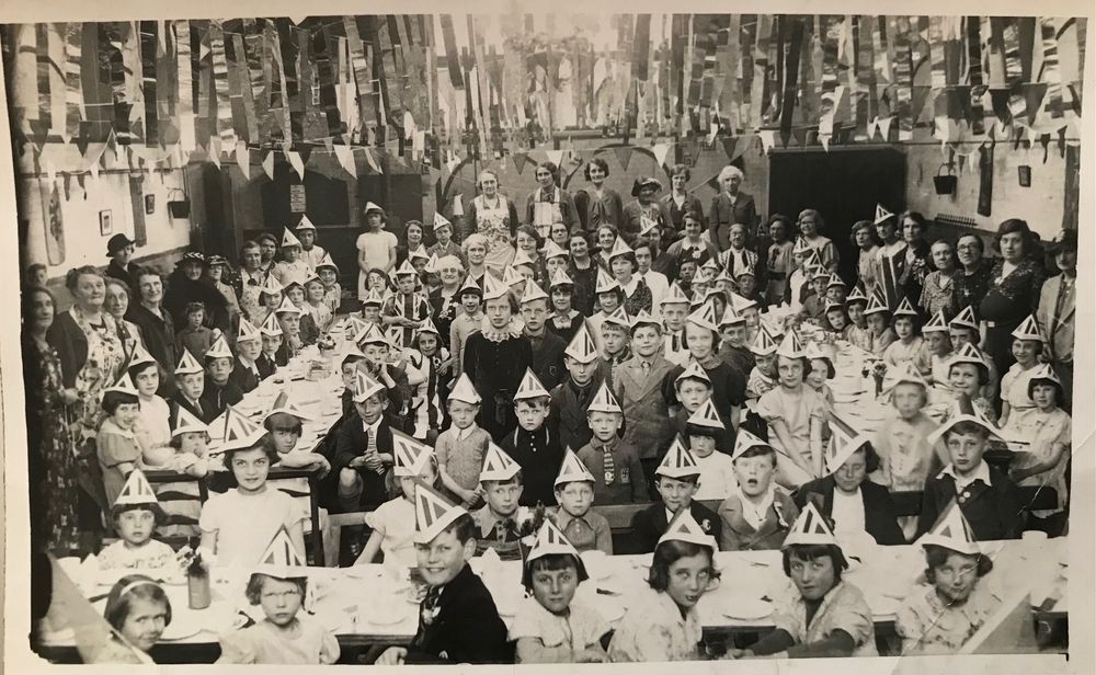 Children and parents enjoy a VE Day tea party in 1945