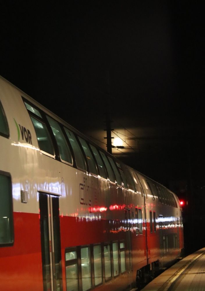 Zug der ÖBB am Bahnsteig mit dem Mond darüber 
