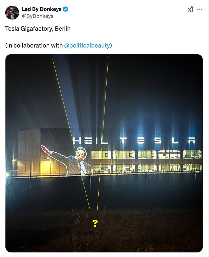 Doctored photo of tesla factory saying "heil tesla" in lighting letters and picture of elon doing "roman" salute. 