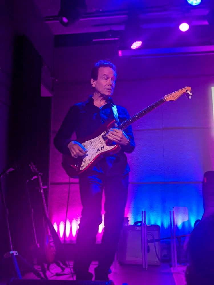 Arthur Neilson playing electric guitar on stage