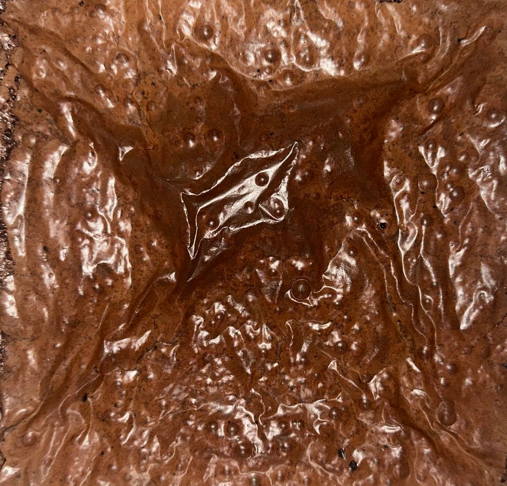 foto vista de cima de uma forma de brownie de café. na cor marrom, é possível ver a casquinha quebradiça 