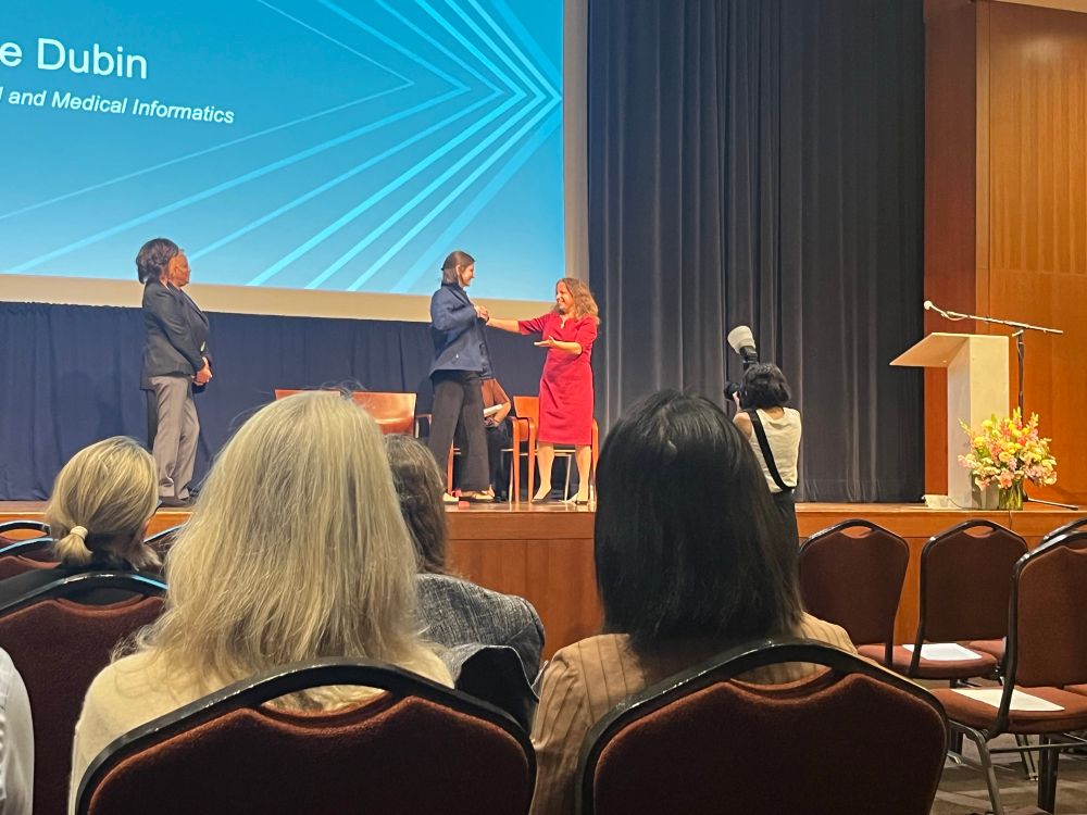 Claire Dubin being coated by Marina Sirota during first annual PhD Candidate Ceremony