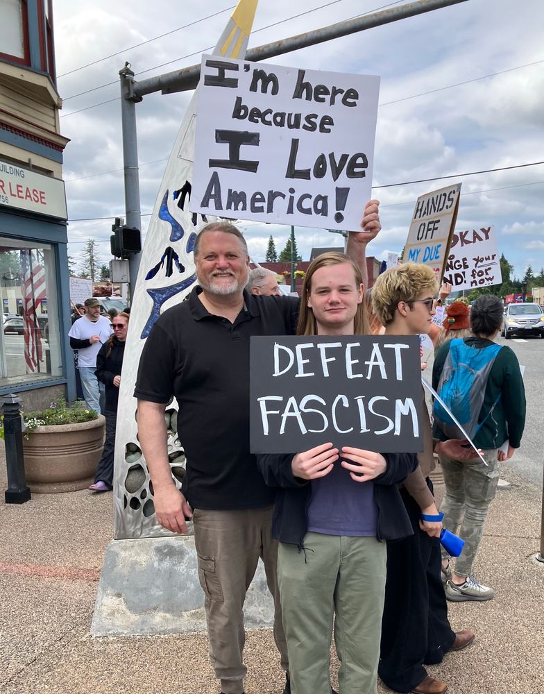 Protesting with signs saying “defeat fascism” and “I’m here because I love America”