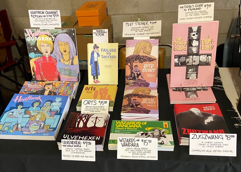 Photo of various of my indie comics laid out for display 