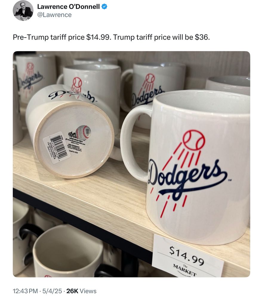 A tweet from Lawrence O’Donnell showing a shelf of white ceramic Dodgers mugs priced at $14.99. The caption reads: “Pre-Trump tariff price $14.99. Trump tariff price will be $36.” One mug is flipped to show a barcode and “Made in China” label, suggesting the price hike is due to Trump’s tariff policy.
