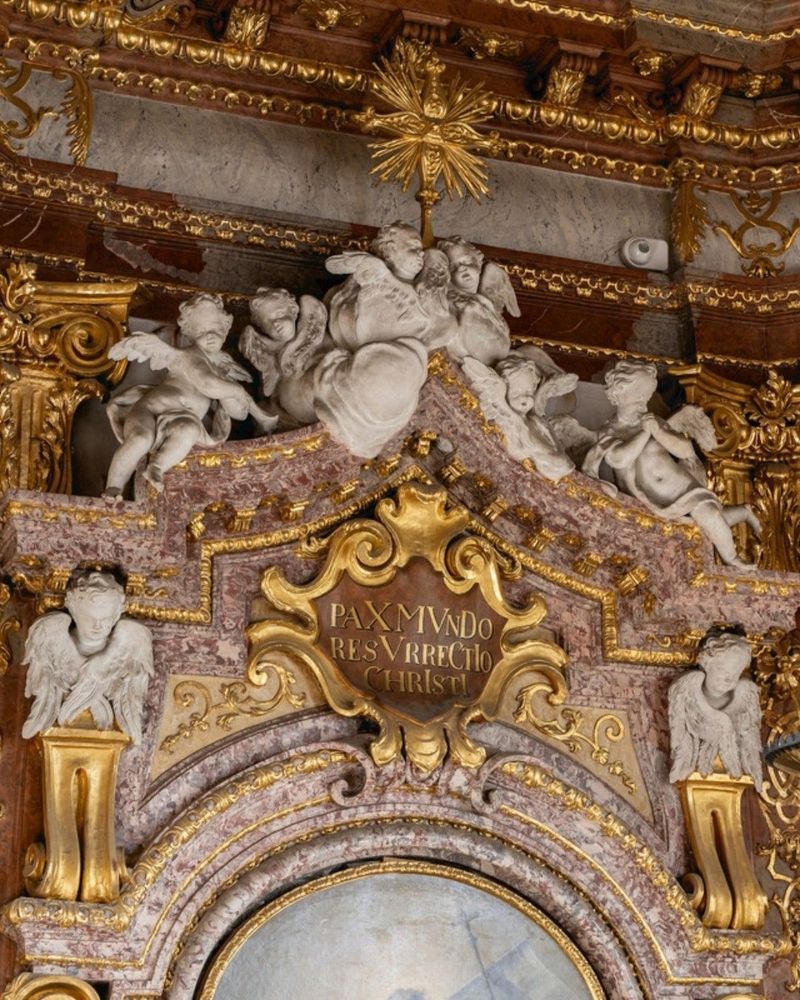 A highly ornate and gilded ecclesiastical architectural interior with intricately carved and sculpted figures and decorations, including a large central composition depicting the Resurrection of Christ.