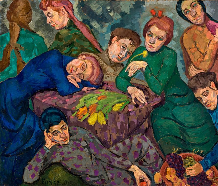 A group of people in colorful clothing gathered around a bed with a floral bedspread, suggesting a scene of care and concern.