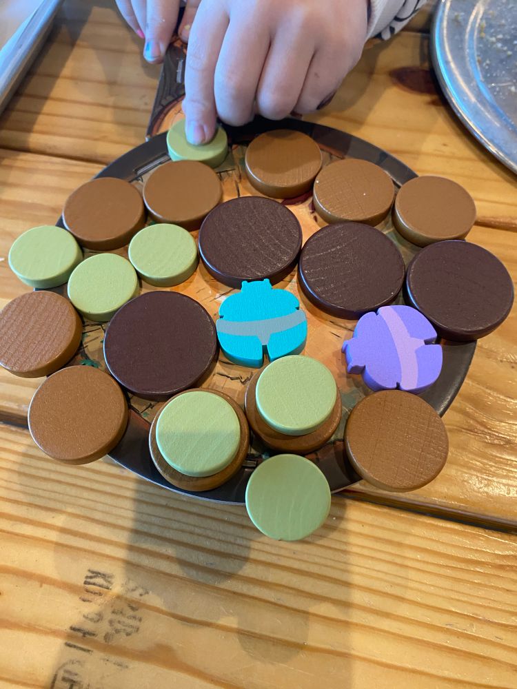 Kabuto Sumo from above, a small hand pushing a disc onto the board