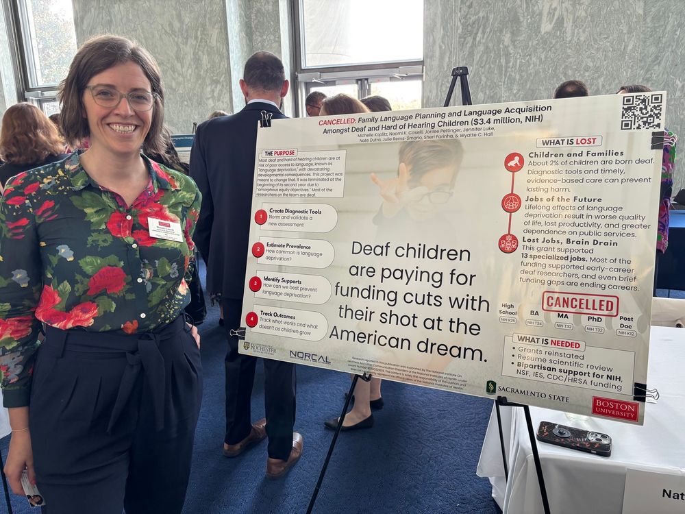 Dr. Naomi Casselli stands in front of her poster describing her cancelled grant on family language planning.  
