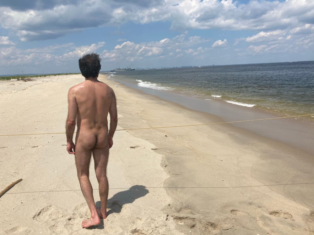 Me au naturel on the beach with a faint NYC skyline on the horizon 