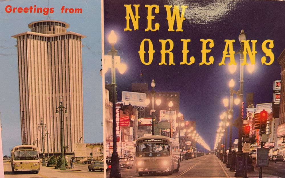 A photo of an old postcard (circa 1960s?) of New Orleans, with the text "Greetings from New Orleans." On the left side is an image of the former New Orleans World Trade Center tower (now a hotel) during the day. On the right is a photo from the corner of Bourbon and Canal Streets at night. 