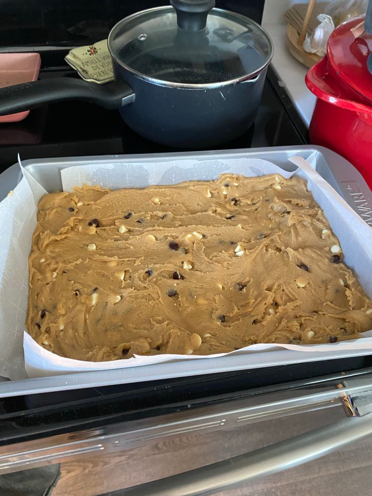 A 9 x 13 tray of blondie batter studded with semisweet and white chocolate chips. 