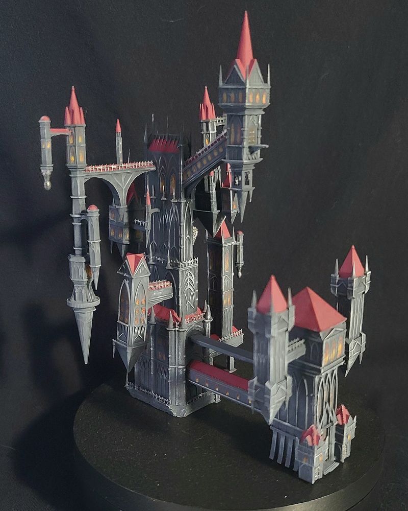 3D printed model of Dracula's Castle, loaded with gothic spires and unorthodox architecture, painted and drybrushed in tones of grey, with wine red roofing.