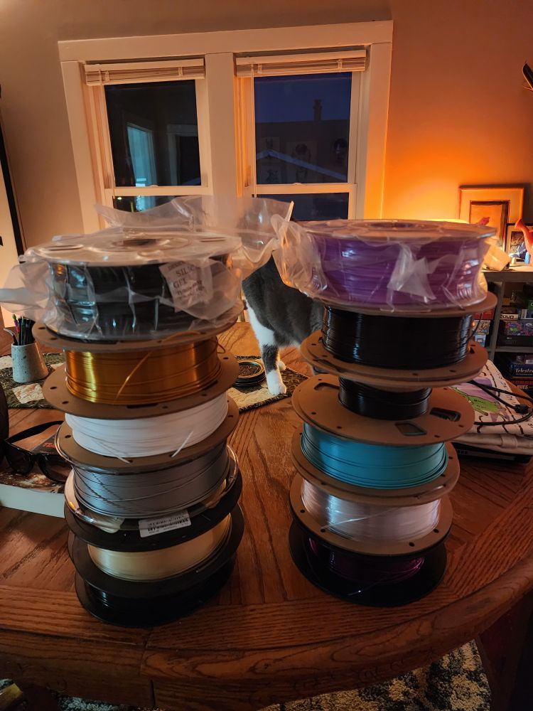 A large pile of various 3D printing filaments