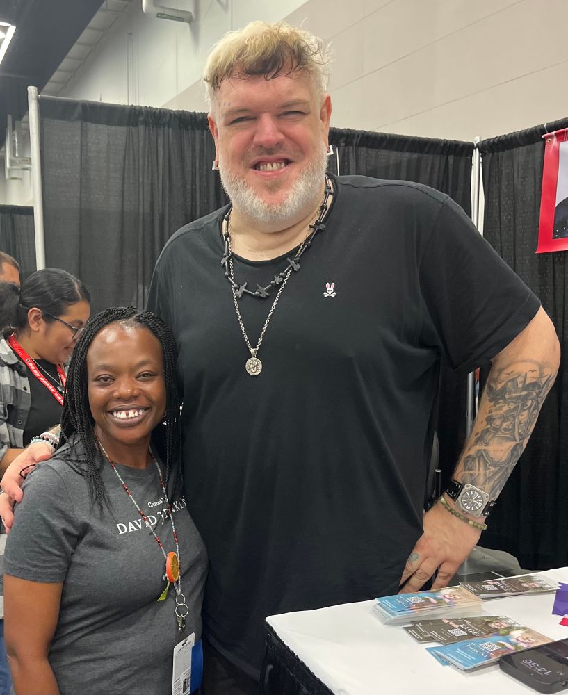 An absurdly cute photo of a very tall person in a black t-shirt and a very short person in a grey t-shirt.  